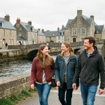 Groupe de deux femmes et deux hommes souriants découvrant une ville bretonne au bord de l’eau, dans une ambiance de loisirs urbains et de lumière douce.