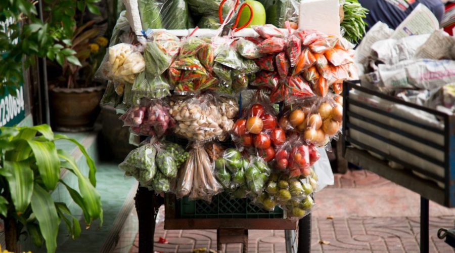 Des visiteurs explorent un marché couvert en Martinique pendant une journée pluvieuse.