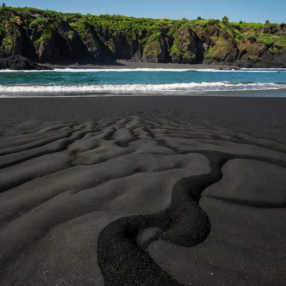 Baie tropicale de la Dominique avec une plage volcanique et des eaux calmes.