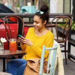 Voyageur utilisant son téléphone dans un café à La Havane pour vérifier son paiement et sa connexion internet.