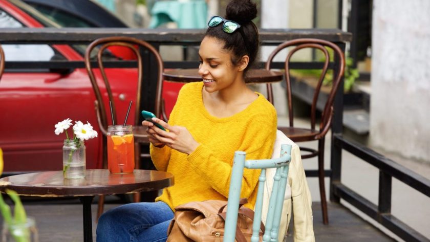 Voyageur utilisant son téléphone dans un café à La Havane pour vérifier son paiement et sa connexion internet.